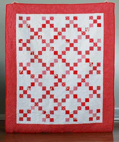 Red and white Irish chain quilt with two borders