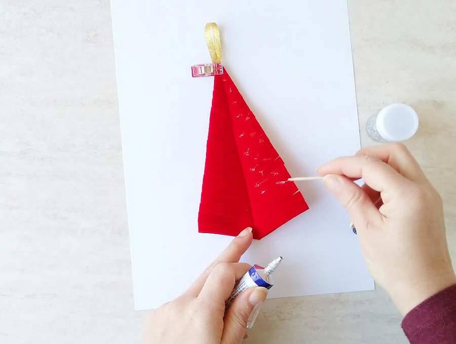 dots of glue on top of the christmas tree ornament