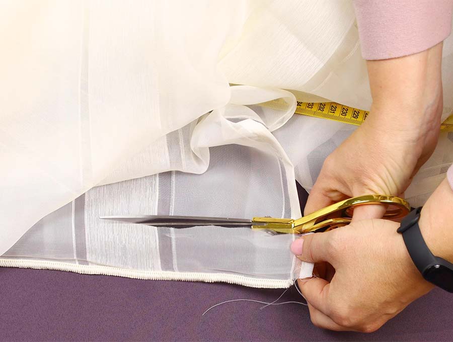cutting excess fabric from curtains before hemming