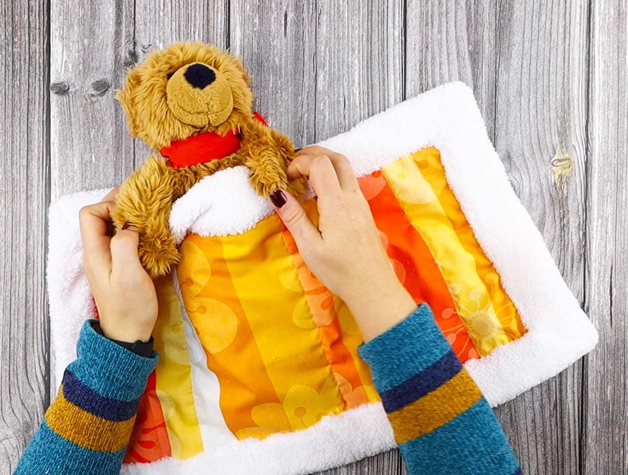 using the sherpa fleece blanket to cover a bear toy